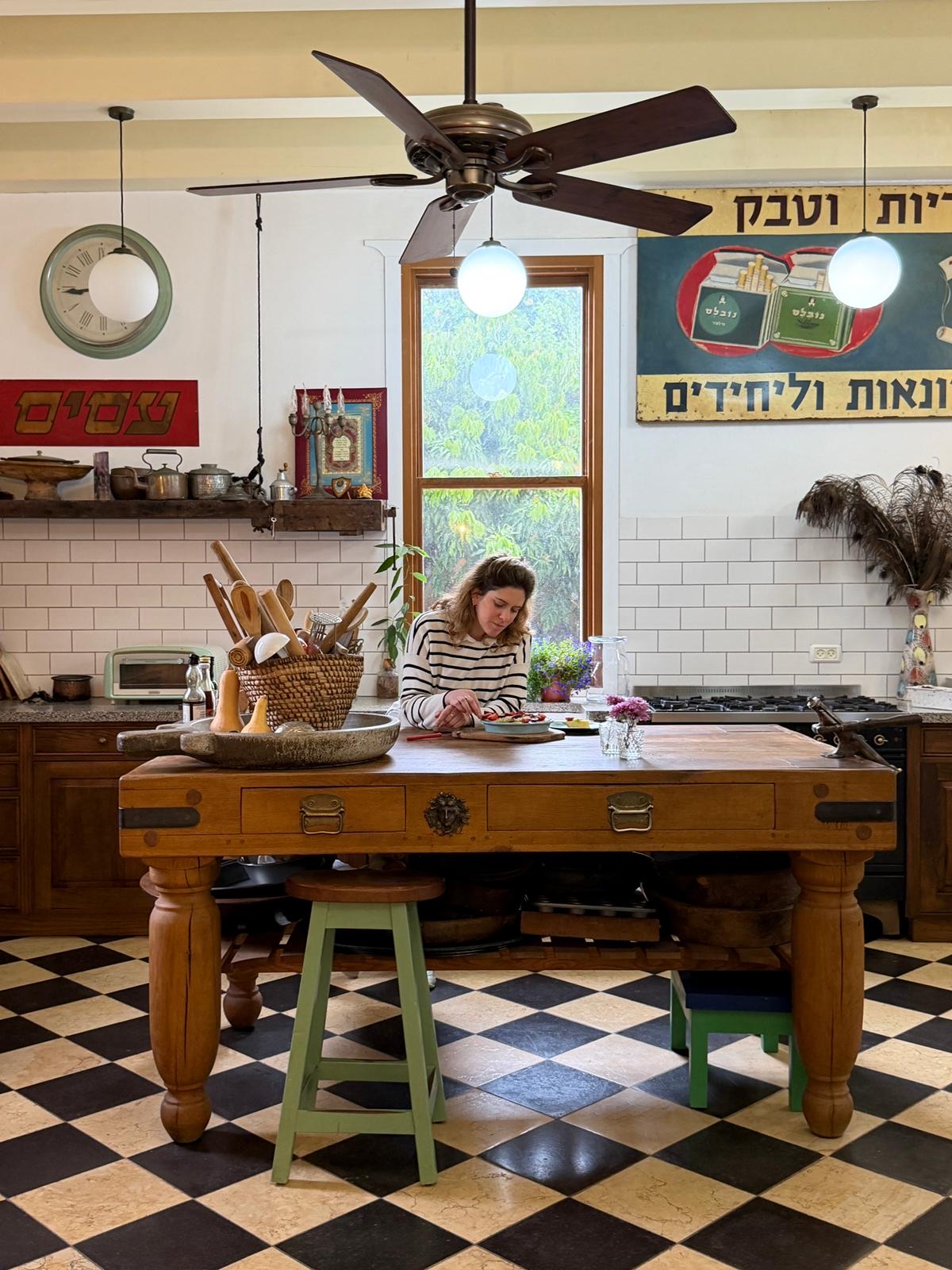 יעל במטבח הסטודיו, ליד שולחן העץ